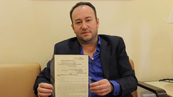 الفتياني يعرض وثيقة تثبت ملكية عائلته لأرض السفارة الأميركية (الجزيرة)