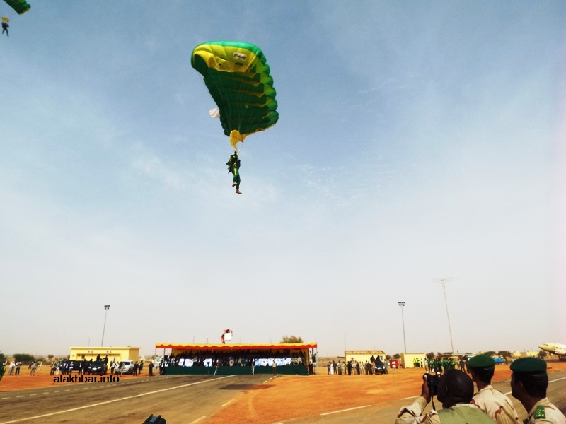 نفذ المظليون إنزالا أمام المنصة الرسمية احتفطوا خلاله بألوان العلم القديم في زيهم الشخصي ومظلاتهم (الأخبار)