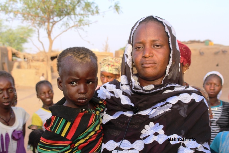 الطفل واكي مع السيدة التي تولت كفاله بعد رحيل والدته (الأخبار)