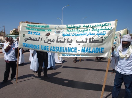 العمال المنضوون تحت الكونفدرالية الوطنية للشغيلة الموريتانية يحملون شعاراتهم في المسيرة على شارع جمال عبد الناصر نحو ساحة مسجد اين عباس (تصوير ـ الأخبار)