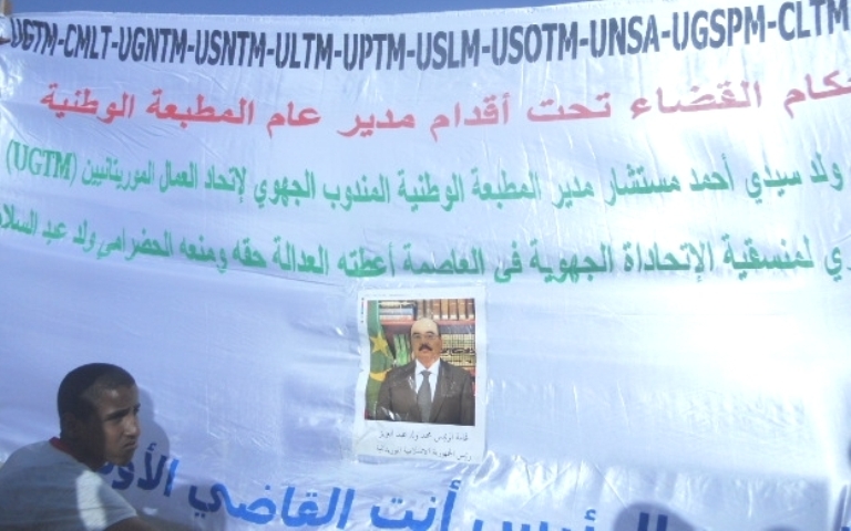 هذا الشاب جاء بلافتته احتجاجا على ظلم مدير المطبعة الوطنية له، لكن القائمين على التظاهرة منعوه من رفعها وشكوه إلى الشرطة الذين أمروه بالخروج  من الساحة (الأخبار)