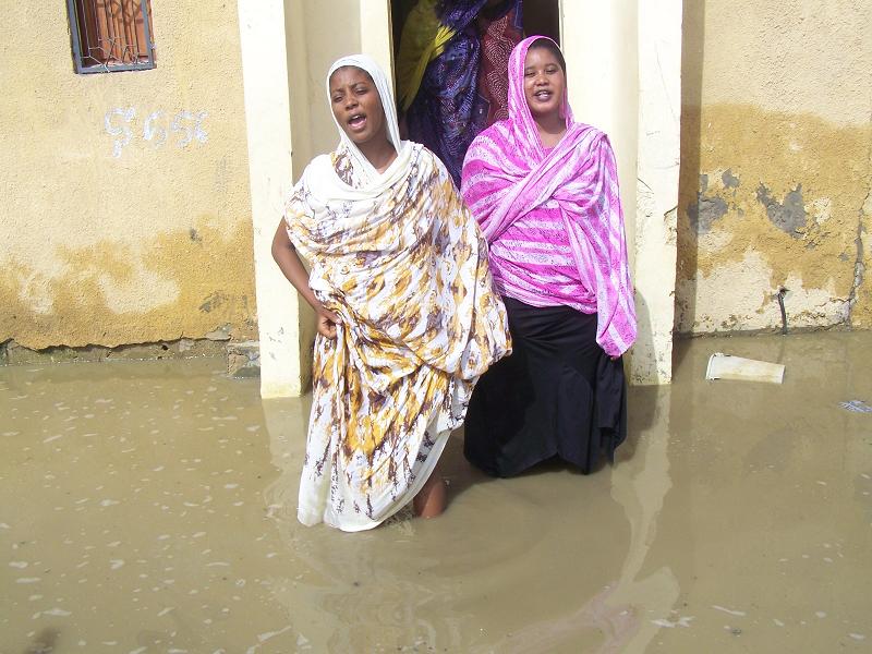 بنتي بوبه نزلتا من عتبة الباب فوصل الماء ركبهن ومع ذلك تصر أمهن على البقاء (تصوير الأخبار)