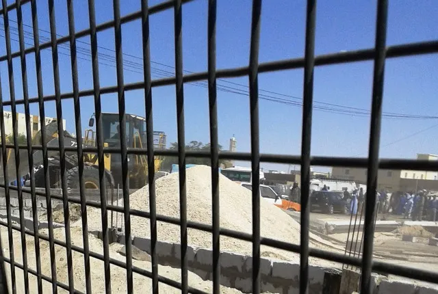 جرافة تابعة لشركة صيانة الطرق تولت تسوية الحائط بالأرض تحت حماية وحد