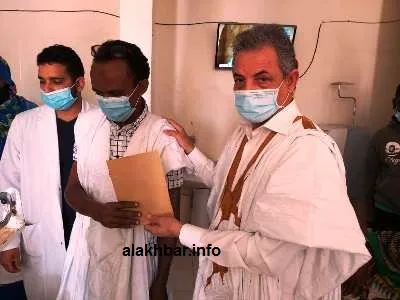العمدة أثناء تسليمه المبلغ المالي في ظرف لأحد المستفيدين / الأخبار