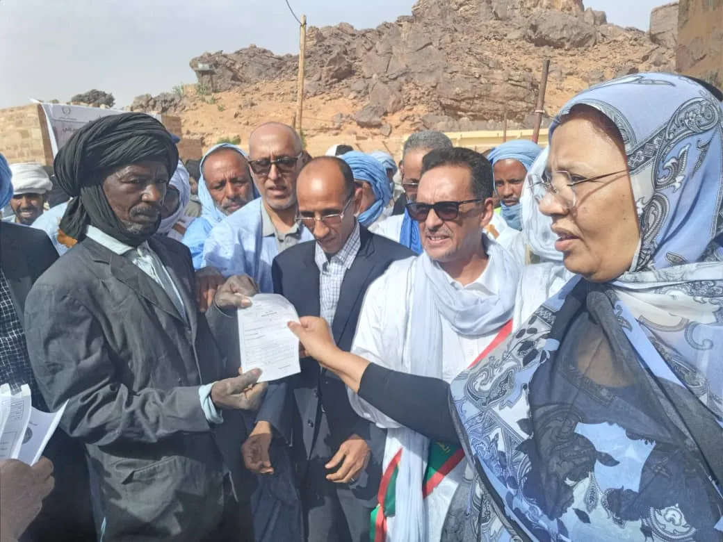 مفوضة الأمن الغذائي فاطمة بنت خطري تسلم وصلا لأحد المستفيدين من العم